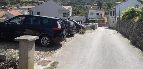 un paio di auto parcheggiate sul ciglio di una strada di Apartments Bilić a Vis
