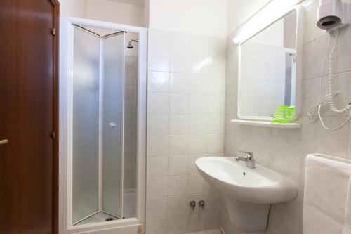 La salle de bains blanche est pourvue d'un lavabo et d'une douche. dans l'établissement Hotel Garden, à Giulianova