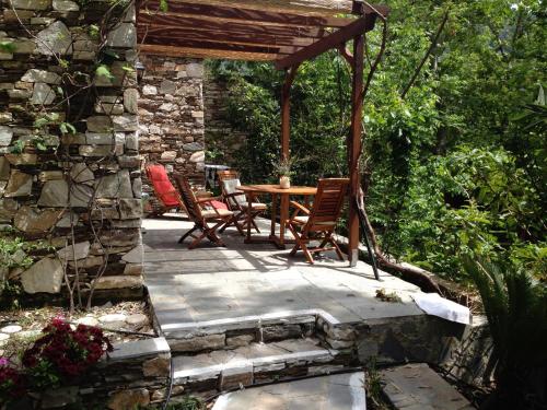 a patio with a table and chairs and a stone wall at Valeondades in Valeontádes