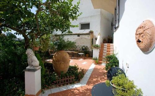 um jardim com um grande vaso ao lado de uma casa em B&B Angelide em Anacapri