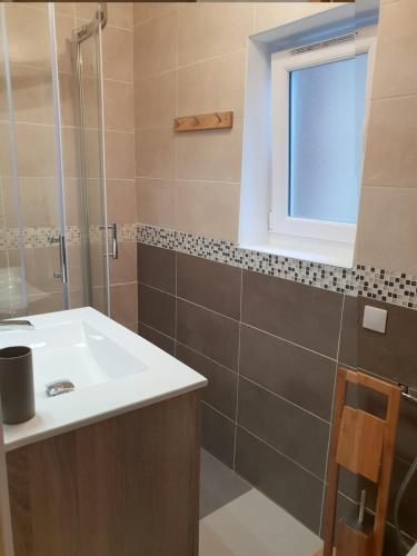 une salle de bain avec un lavabo et une douche dans l'établissement Le verger d'Honfleur, à Honfleur