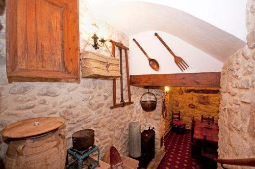 uma cozinha com armários de madeira e utensílios na parede em Casa La Torre em Torremanzanas