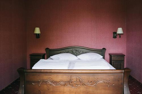 a bed with white sheets and pillows in a bedroom at Shelter Hotel & Restaurant in Kolodezhno