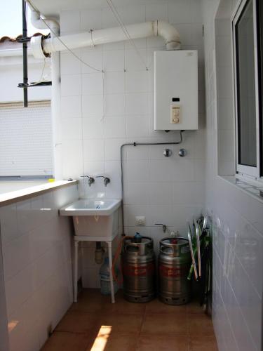 a small white bathroom with a sink and two buckets at Ayamonte Mirador in Ayamonte