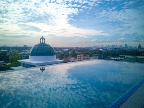 a large swimming pool on the roof of a building at Romance Hotel Sukhumvit 97 in Bangkok