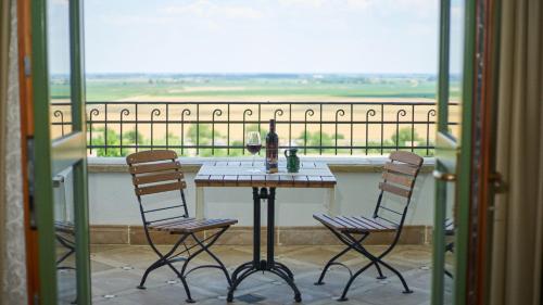 a table and chairs on a balcony with a view at Takler Kúria in Szekszárd