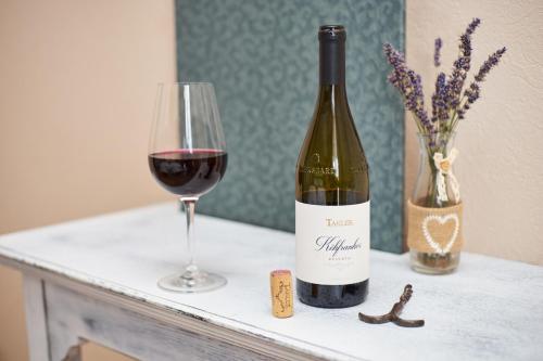 a bottle of wine and a glass on a table at Takler Kúria in Szekszárd
