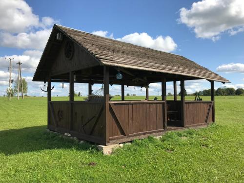a wooden pavilion in the middle of a field at SKY Ranch in Izborsk