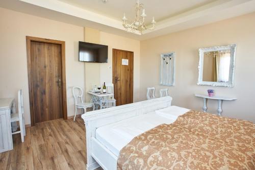 a bedroom with a bed and a table and chairs at Takler Kúria in Szekszárd