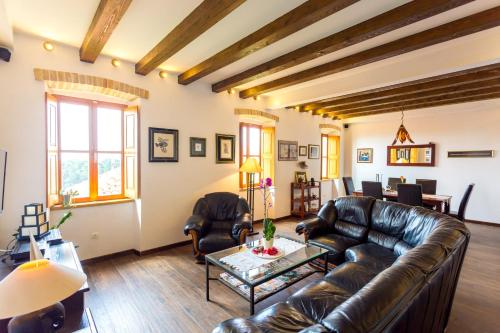 a living room with a leather couch and a table at Villa Anica Dubrovnik - luxurious with a sea view in Dubrovnik