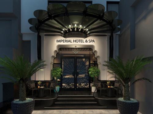 an entrance to an imperial hotel and spa with palm trees at Imperial Hotel & Spa in Hanoi