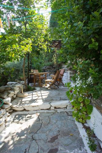 a patio with two chairs and a table and trees at Valeondades in Valeontádes