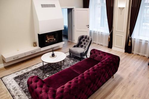 sala de estar con sofá, mesa y chimenea en Kranto apartamentai, en Panevėžys