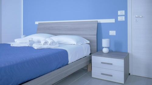 
a bed with a blue and white comforter and a blue and white at Naxos Laguna Beach in Giardini Naxos
