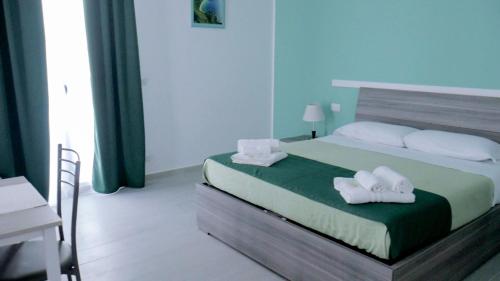 a bedroom with a bed with white towels on it at Naxos Laguna Beach in Giardini Naxos