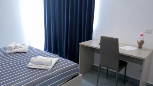 a room with a bed with a desk and a desk at Naxos Laguna Beach in Giardini Naxos