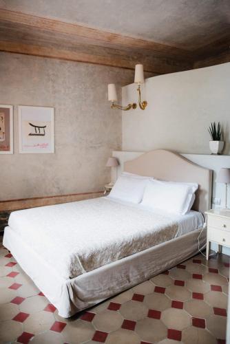 a bedroom with a large white bed and a table at Regina Teodolinda Suites in Laglio