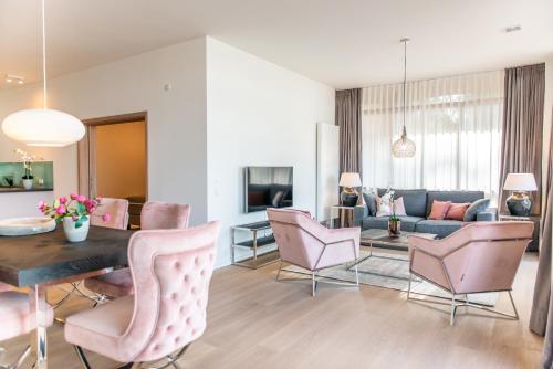 a living room with a couch and a table and chairs at Intermar Hotel & Apartments in Glücksburg