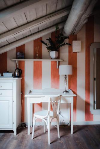 a white table and chairs in a room with orange and white stripes at Regina Teodolinda Suites in Laglio