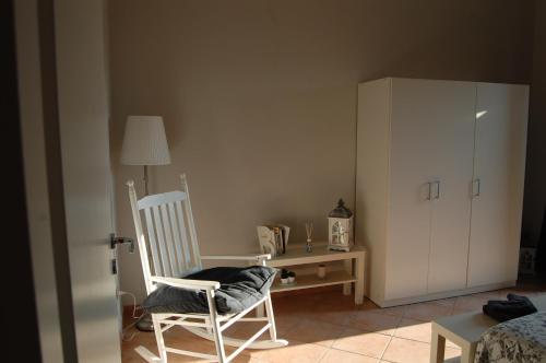 a bedroom with a chair and a desk and a cabinet at La Loggetta sul Borgo in Formello