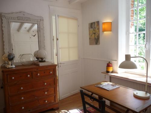 Cette chambre comprend une commode, une table et un miroir. dans l'établissement Le clos du Ru, à Presnoy