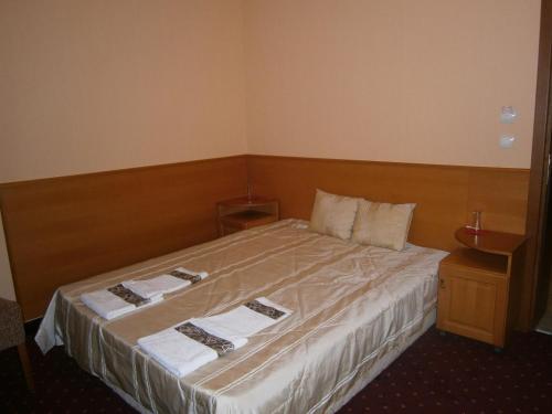 a bedroom with a large bed with towels on it at Evia Hotel in Berkovitsa