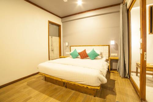 a bedroom with a large white bed with pillows at By the shade Maldives in Hangnaameedhoo