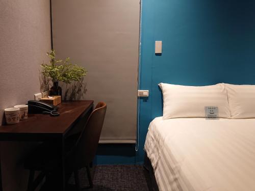 a hotel room with a bed and a desk with a bed sidx sidx sidx at Cho Hotel 3 in Taipei