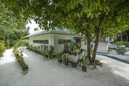 a building with a lot of plants in front of it at By the shade Maldives in Hangnaameedhoo