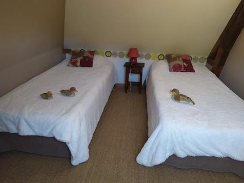 two beds with stuffed animals on them in a room at DUCK HOUSE in Saint-Wandrille-Rançon