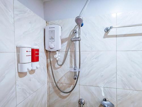 a shower in a bathroom with a hair dryer at RedDoorz near Notre Dame of Dadiangas University in General Santos
