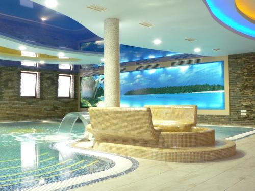 una piscina con 2 sillas y una pantalla grande en SPA-Hotel Dodo, en Zhytómyr