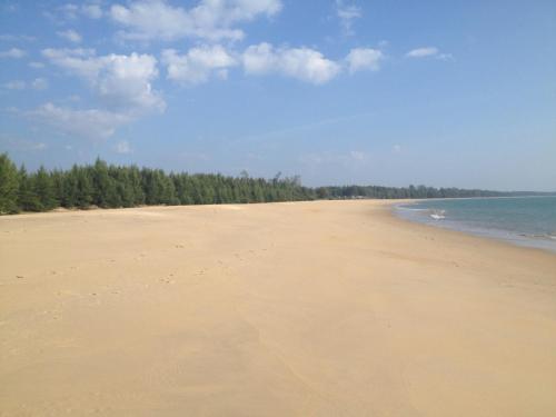 a sandy beach with trees on the horizon at Paradis Villa B3 in Ko Kho Khao