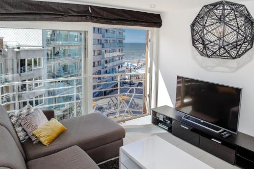 ein Wohnzimmer mit Couch und großem Fenster in der Unterkunft Lumina Suite Seaview & Garage in Middelkerke