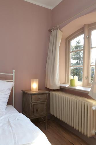 a bedroom with a bed and a window with a radiator at Gutshaus Lexow in Lexow