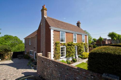 a brick house with a brick wall in front of it at Boreham House in Herstmonceux