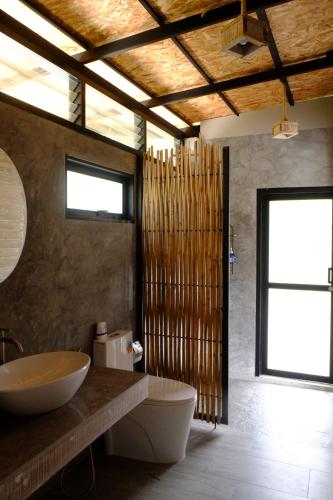 a bathroom with a toilet and a sink and a window at Awana Villa Resort Yaonoi - SHA Extra Plus in Ko Yao Noi
