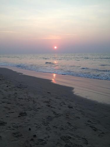 a sunset on a beach with the ocean at Paradis Villa B3 in Ko Kho Khao