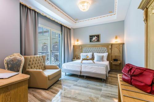 a hotel room with a bed and a chair at Wellness Santa Hotel - adults plus12 in Agia Triada