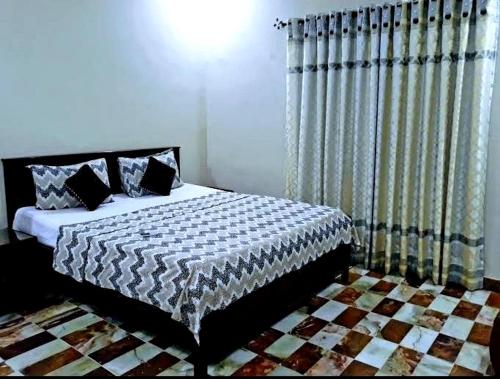 a bedroom with a bed and a window with curtains at Gulshan E Jamal Guest House in Karachi