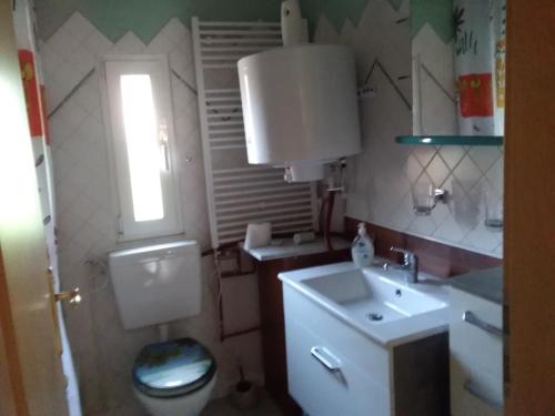 a bathroom with a toilet and a sink and a window at Gartenhaus in Berlin