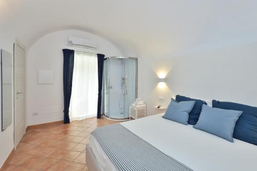 a hotel room with a white bed and white walls at Casa Amorino in Minori