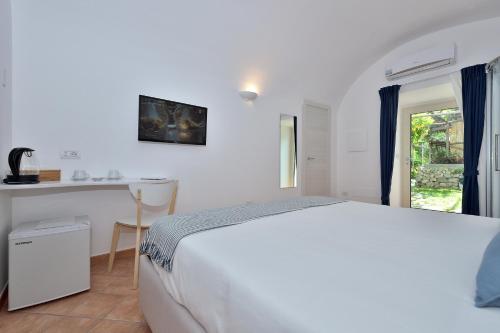 a bedroom with a white bed and white walls at Casa Amorino in Minori
