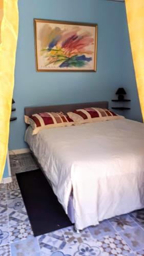 une chambre avec un lit blanc avec un tableau sur le mur dans l'établissement Château de l Herm, Lascaux, Sarlat, en Périgord Noir, à Rouffignac-Saint-Cernin-de-Reilhac