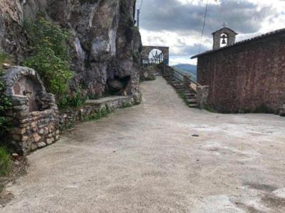 a stone path leading to a building with a church at Cal Fuste in Torà de Tost