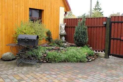 a garden with a grill in front of a fence at Amrai in Ventspils