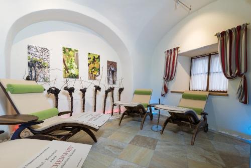 a room with chairs and tables and windows at Hotel-Restaurant Kirchenwirt in Weissenkirchen in der Wachau