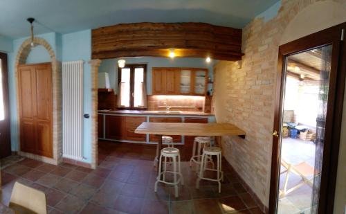 a kitchen with a wooden table and stools at Casa LEPRICE in SantʼElpidio a Mare