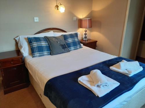 um quarto com uma cama com toalhas em The Imperial Hotel em Castle Douglas
