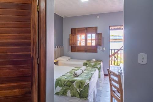 a bedroom with a bed and a room with a window at Pousada Blue Viking in Praia do Frances